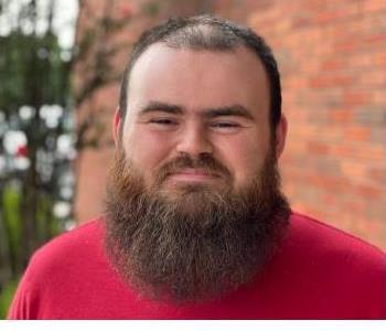 Employee photo with beard red shirt with brick background