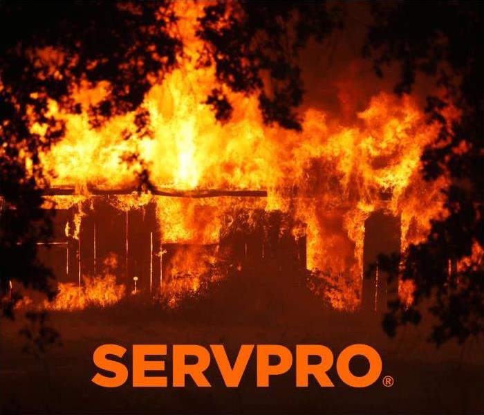 flames engulfing home and fence with Servpro logo  