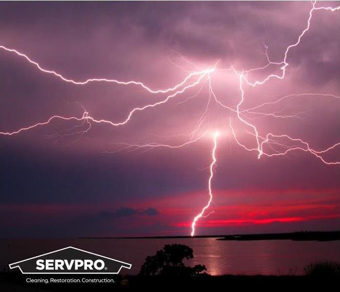lightning strike acros sky over water with SERVPRO logo
